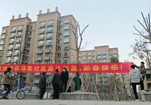 菏泽东明县马集社区居民挂上喜迁新居,新春快乐的横幅